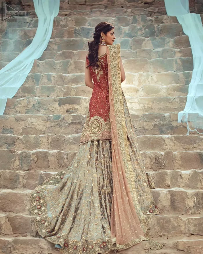 An uplifting look for any formal occasion. This wedding outfit is emphasized with zardozi work. The shirt is beautifully decorated with embroidered neckline, a central geometric motif on the border, and scattered tiny floral motifs all over the ground. Pair it up with a pastel green back train lehenga enhancing with the art of classical heritage showcasing the craftsmanship of zardozi work, multiple colors embroidery, and finishing with scalloped borders. The outfit is coordinated with a net dupatta with hand-embroidered borders on all four sides and sequins spray on the ground.