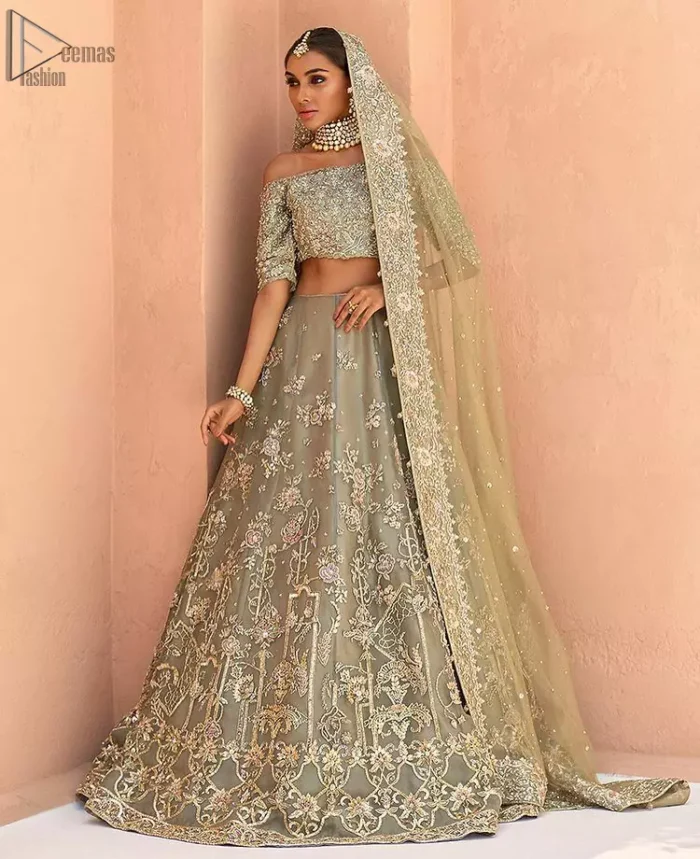 When extreme beauty is your identity, the Olive Green Off Shoulder Blouse Lehenga makes sure it boosts your gorgeousness with its much more attractive elegance. This paragon of exquisiteness is designed with three-quarter sleeves, making sure it meticulously matches its objective. The silver and golden embroidery serve as the cherry on top, while the stunning floral motifs do not fail to catch all admiring eyes on the finest details of adornment on the dress. Finest organza as always is the prime choice for an attire so meritorious and the concluding marvellous net dupatta prepares this laudable dress to brighten up your Walima ceremony.