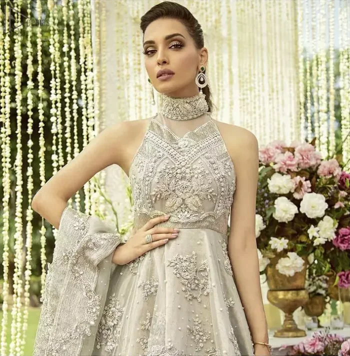 Drape yourself to perfection for the classiest affair in this flattering pastel green ensemble festooned with intricate zardozi hand embroidery work & motifs. The back train peplum is adorned with a halter neckline and beautifully embellished bodice with silver zardozi work. The rest of the peplum is emphasized with a delicate arrangement of hand-embellished floral bunches and scattered sequins spray all over. Accompanied by a matching lehenga decorated with silver zardozi work. Elegance is personified when it gets paired up with a pastel green dupatta having chann and applique finishing all around the edges.
