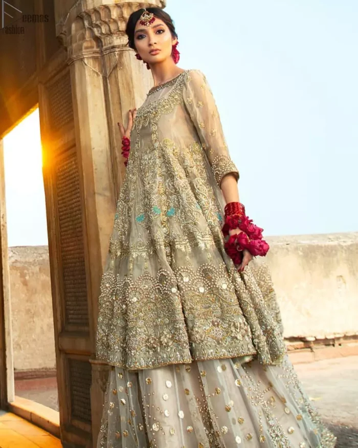 Pastel Green Double Layer Frock - Tea Rose Sharara. Fabulously stitched, Pastel Green double flared frock in maxi style is exquisite indeed. Fully embellished with tilla, dabka, sequins, pearls and silk thread embroidery. The frock body is entirely composed of pure organza with one part round neckline. Frock comes with three-quarter sleeves and it is concealed with a side zip closure. Tea rose pure tissue sharara with decently composed with fixed waist belt with side zip closure is one to wear on nikah or on a wedding day.