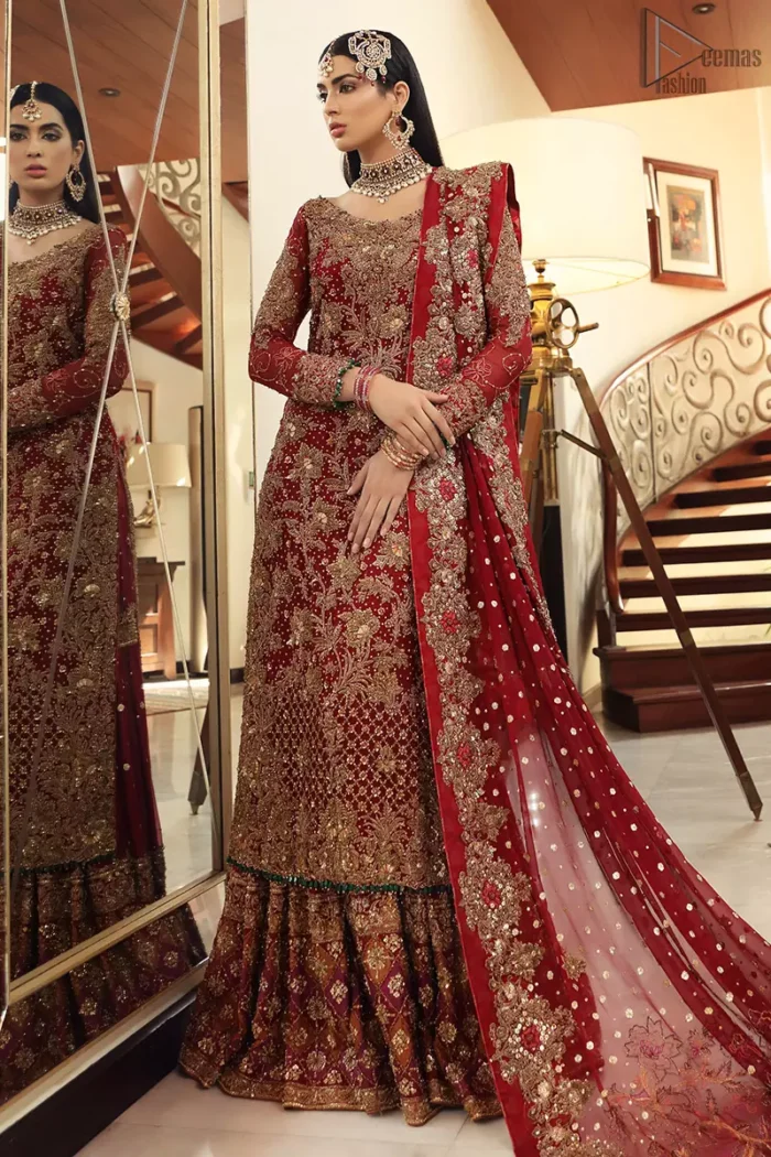 Maroon bridal wear long shirt, appliqued Gharara and matching heavily embroidered dupatta. We will make you believe in fairy-tales! Ethereal handcrafted luxe ensemble, fit for a princess glammed out with gorgeous layers of hand-embroidered details, timeless silhouette and dreamy embellishment. The outfit is finished with beautiful maroon organza gharara having appliqued embroidery below the gott. This colourful gharara having thick embroidery borders gives it a regal look.