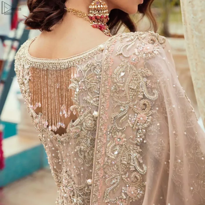 Bringing traditional charm to your big day with intricately silver and light golden embellished neckline and thick worked lines all around the flare on Tea rose canvas of Pishwas. Tea Rose pure Organza Pishwas adorned with heavy embroidery all over it. The nikah Pishwas has beautiful danglings on the back of the neckline and it comes with a pure banarsi jamawar lehenga having large thick borders on the hemline. This nikah wear tea rose Pishwas, pure banarsi jamawar lehenga comes with pure organza embroidered border dupatta.