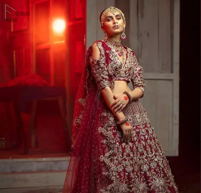 Maroon Pakistani bridal wear half blouse and lehenga comes with dupatta. Deep red half blouse choli along with same colour Lehenga of Organza Fabric with Golden-Ivory Embroidery is Everything. For a Bride planning, some exceptional outfit here comes the fully embellished, geometrical shapes having half sleeves for her Reception. The V-Neckline unifies the whole outfit with fully sprayed Tilla, Dabka work with floral motifs on Blouse Choli, Lehenga and Net Dupatta of Organza Fabric. The Lehenga has finished edges with full flare and fixed waist belt with a side zip closure along with dupatta of same deep red colour with heavy full embellished four borders.