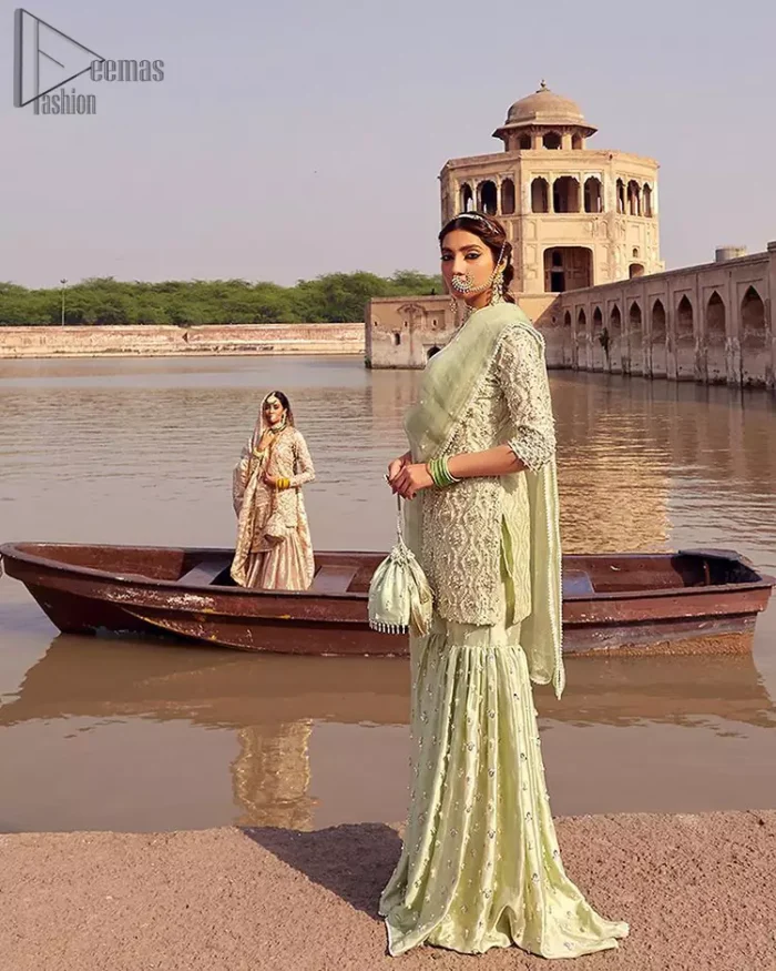 Glow up an evening formal event with a Light Parrot Green Gharara Shirt, a beautiful three-quartered sleeves shirt designed with the most accurate round neckline to make you appear the star of the night. But a star as beautiful as you need to sparkle bright, which is why the dress is adorned with an outstanding work of silver and gold embroidery and ornamented with glittering pearls. This beautiful dress is designed in a matching embellishment with criss-cross patterns to help you dress up precisely. Finally, an organza dupatta concludes your magical gorgeousness.