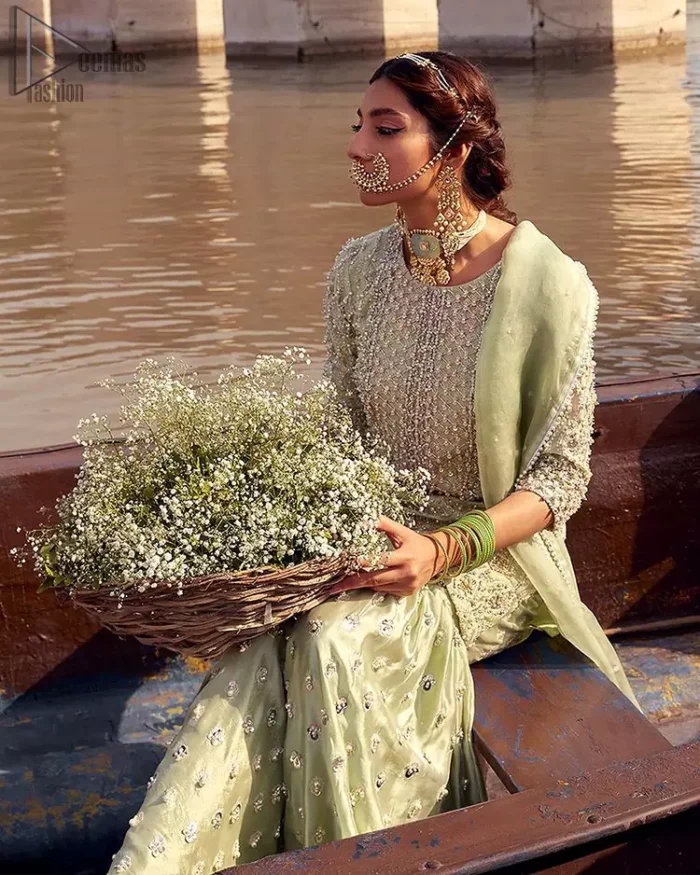 Glow up an evening formal event with a Light Parrot Green Gharara Shirt, a beautiful three-quartered sleeves shirt designed with the most accurate round neckline to make you appear the star of the night. But a star as beautiful as you need to sparkle bright, which is why the dress is adorned with an outstanding work of silver and gold embroidery and ornamented with glittering pearls. This beautiful dress is designed in a matching embellishment with criss-cross patterns to help you dress up precisely. Finally, an organza dupatta concludes your magical gorgeousness.