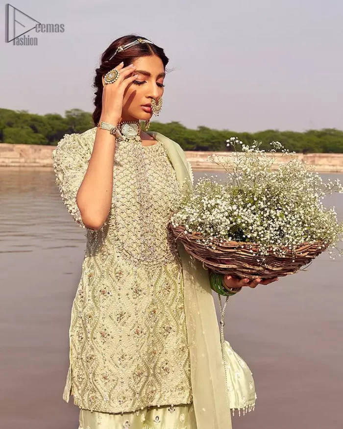 Glow up an evening formal event with a Light Parrot Green Gharara Shirt, a beautiful three-quartered sleeves shirt designed with the most accurate round neckline to make you appear the star of the night. But a star as beautiful as you need to sparkle bright, which is why the dress is adorned with an outstanding work of silver and gold embroidery and ornamented with glittering pearls. This beautiful dress is designed in a matching embellishment with criss-cross patterns to help you dress up precisely. Finally, an organza dupatta concludes your magical gorgeousness.
