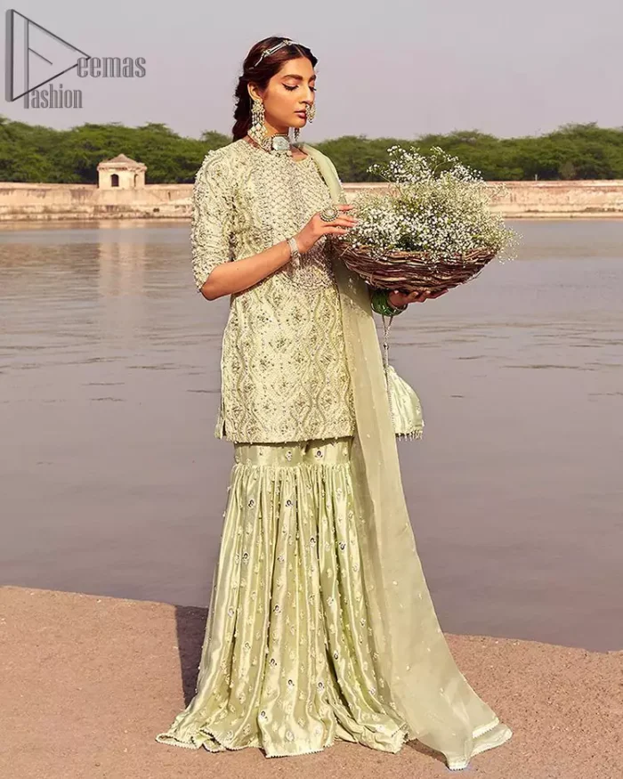 Glow up an evening formal event with a Light Parrot Green Gharara Shirt, a beautiful three-quartered sleeves shirt designed with the most accurate round neckline to make you appear the star of the night. But a star as beautiful as you need to sparkle bright, which is why the dress is adorned with an outstanding work of silver and gold embroidery and ornamented with glittering pearls. This beautiful dress is designed in a matching embellishment with criss-cross patterns to help you dress up precisely. Finally, an organza dupatta concludes your magical gorgeousness.