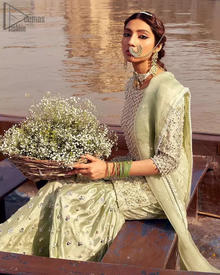 Glow up an evening formal event with a Light Parrot Green Gharara Shirt, a beautiful three-quartered sleeves shirt designed with the most accurate round neckline to make you appear the star of the night. But a star as beautiful as you need to sparkle bright, which is why the dress is adorned with an outstanding work of silver and gold embroidery and ornamented with glittering pearls. This beautiful dress is designed in a matching embellishment with criss-cross patterns to help you dress up precisely. Finally, an organza dupatta concludes your magical gorgeousness.