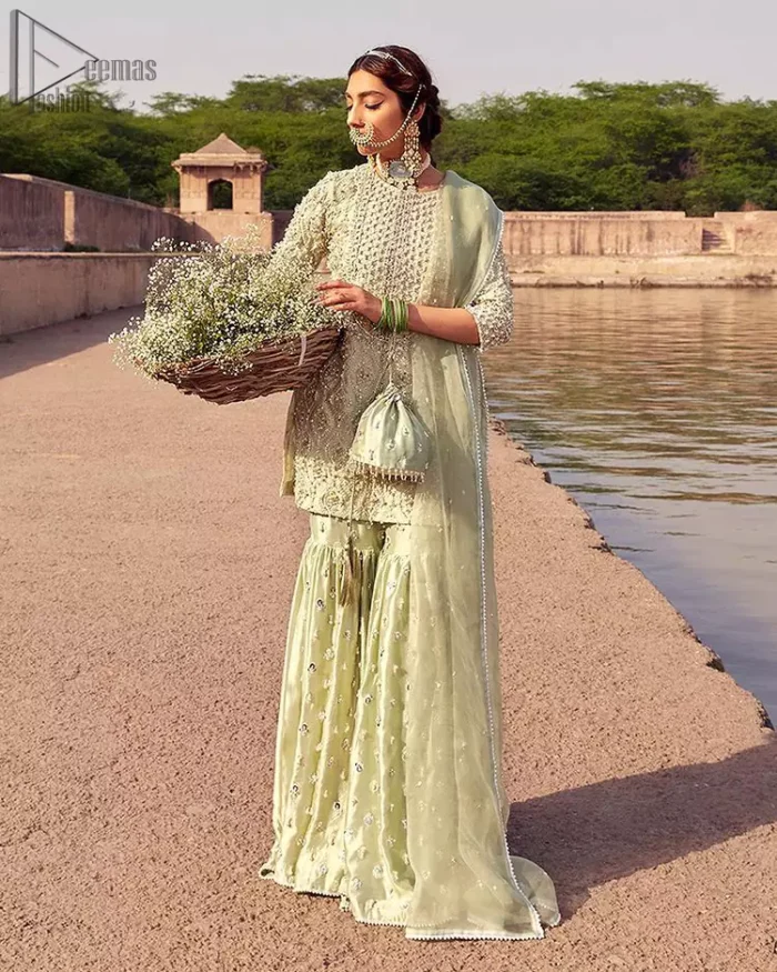 Glow up an evening formal event with a Light Parrot Green Gharara Shirt, a beautiful three-quartered sleeves shirt designed with the most accurate round neckline to make you appear the star of the night. But a star as beautiful as you need to sparkle bright, which is why the dress is adorned with an outstanding work of silver and gold embroidery and ornamented with glittering pearls. This beautiful dress is designed in a matching embellishment with criss-cross patterns to help you dress up precisely. Finally, an organza dupatta concludes your magical gorgeousness.