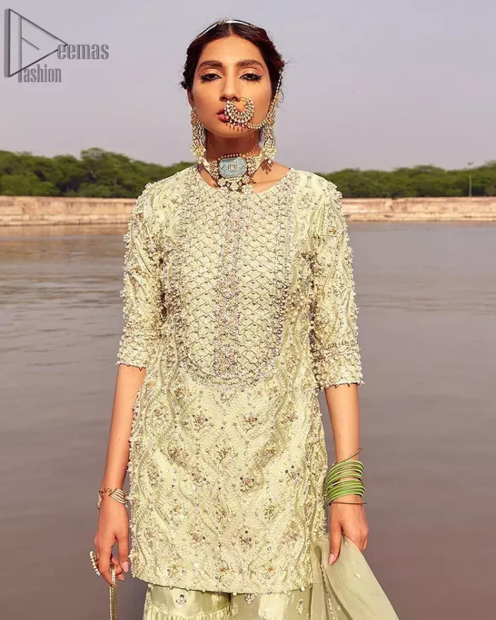 Glow up an evening formal event with a Light Parrot Green Gharara Shirt, a beautiful three-quartered sleeves shirt designed with the most accurate round neckline to make you appear the star of the night. But a star as beautiful as you need to sparkle bright, which is why the dress is adorned with an outstanding work of silver and gold embroidery and ornamented with glittering pearls. This beautiful dress is designed in a matching embellishment with criss-cross patterns to help you dress up precisely. Finally, an organza dupatta concludes your magical gorgeousness.