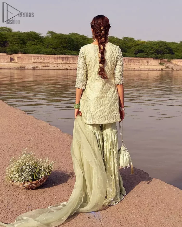 Glow up an evening formal event with a Light Parrot Green Gharara Shirt, a beautiful three-quartered sleeves shirt designed with the most accurate round neckline to make you appear the star of the night. But a star as beautiful as you need to sparkle bright, which is why the dress is adorned with an outstanding work of silver and gold embroidery and ornamented with glittering pearls. This beautiful dress is designed in a matching embellishment with criss-cross patterns to help you dress up precisely. Finally, an organza dupatta concludes your magical gorgeousness.