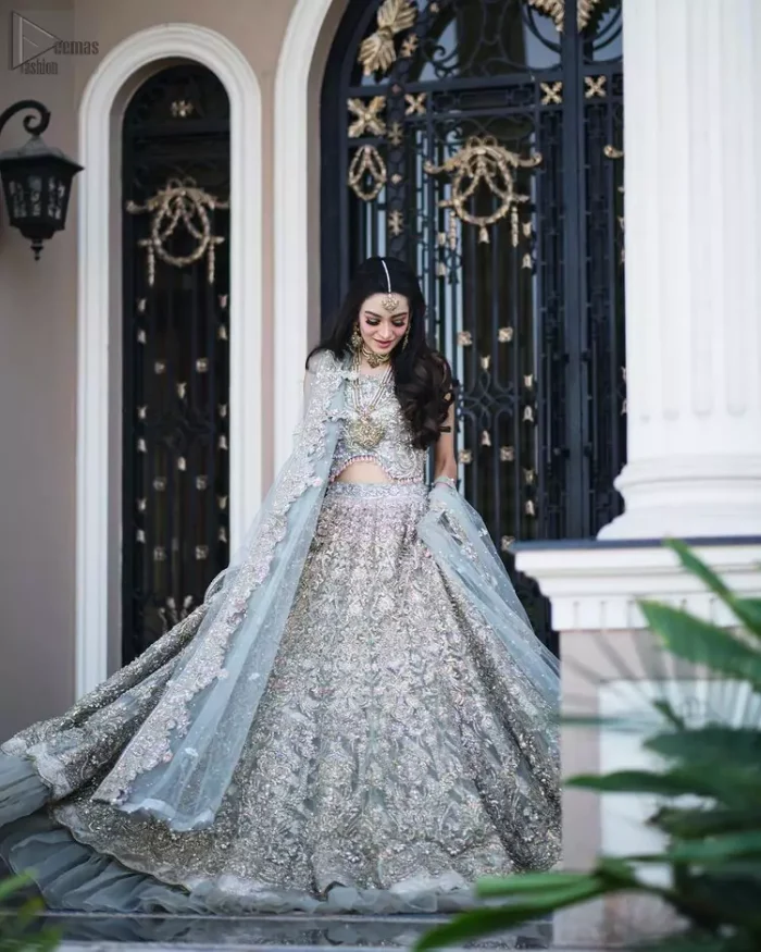 Nikah Wear - Pastel Blue Lehenga Blouse. This pastel blue sleeveless blouse is beautifully sculptured with floral embroidery, adorned with cutwork frilled borders embellished with silver and golden embroidery on lehenga for Pakistani nikah function.