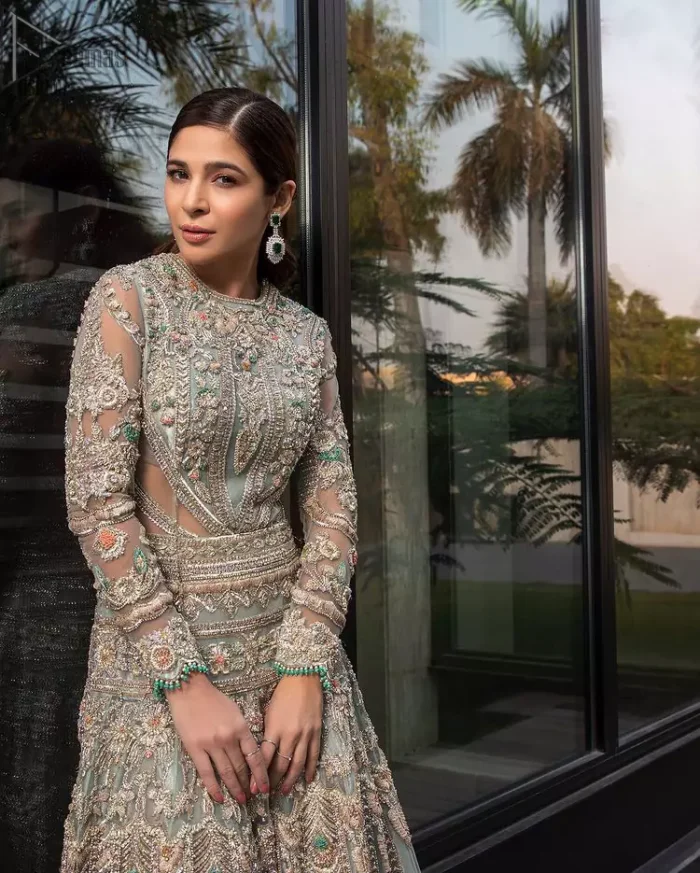 Pastel Green Large Flared Anarkali - Pakistani Wedding Gown. The bottom part of this amazing outfit comprises a lehenga with Fixed Waist Belt With Side Zip Closure. The Ivory i.e silver general embroidery with floral motifs and multicolour embroidery network on organza with finished embellished edges has its own impact. The Dupatta carried sideways have also tissue fabric with embellished four sides and finished edges. Whole this embellishment, the gorgeousness of the costume comes to the spectator noticing eye because of another unifying feature of this outfit that it is 100% imported, pure highest quality fabric.