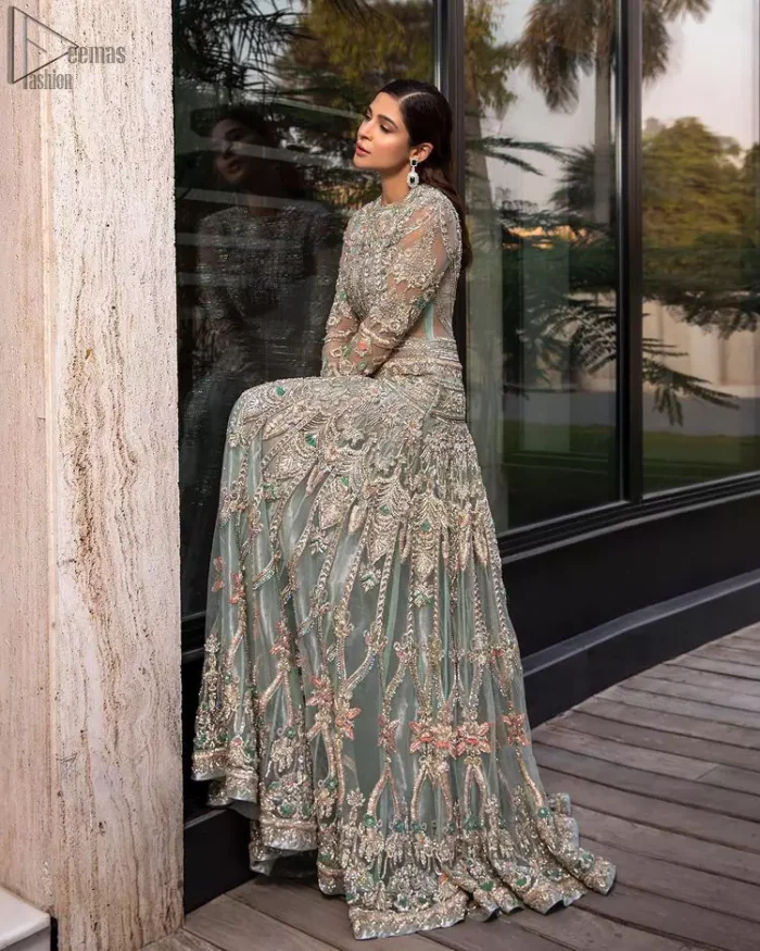 Pastel Green Large Flared Anarkali - Pakistani Wedding Gown. The bottom part of this amazing outfit comprises a lehenga with Fixed Waist Belt With Side Zip Closure. The Ivory i.e silver general embroidery with floral motifs and multicolour embroidery network on organza with finished embellished edges has its own impact. The Dupatta carried sideways have also tissue fabric with embellished four sides and finished edges. Whole this embellishment, the gorgeousness of the costume comes to the spectator noticing eye because of another unifying feature of this outfit that it is 100% imported, pure highest quality fabric.