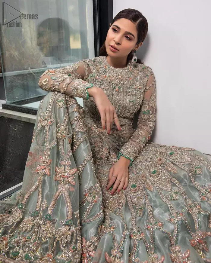 Pastel Green Large Flared Anarkali - Pakistani Wedding Gown. The bottom part of this amazing outfit comprises a lehenga with Fixed Waist Belt With Side Zip Closure. The Ivory i.e silver general embroidery with floral motifs and multicolour embroidery network on organza with finished embellished edges has its own impact. The Dupatta carried sideways have also tissue fabric with embellished four sides and finished edges. Whole this embellishment, the gorgeousness of the costume comes to the spectator noticing eye because of another unifying feature of this outfit that it is 100% imported, pure highest quality fabric.