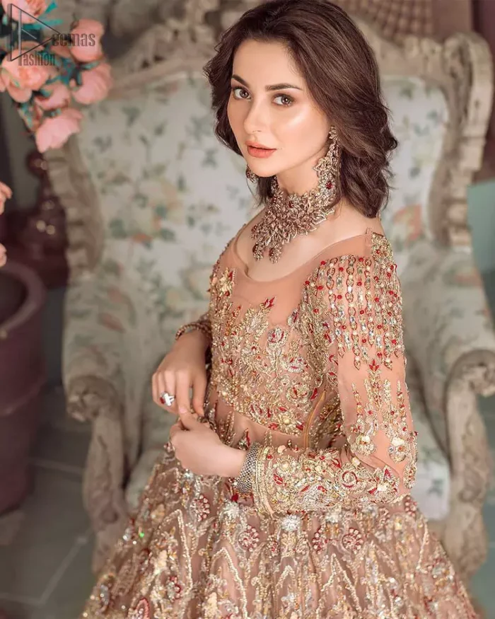 Peach Ruffled Maxi – Back Train Style Dupatta. Peach Blossoming Floral like Maxi with a frilled red border and Organza fabric is a delight to watch worn by the Bride on her Engagement or carried on the Next Day of Reception. With round neckline shape and dense work of red, golden and peach embroidery i.e multi colour conventional tilla, dabka, and Zardozi work with sequins floral motifs and climber networks of beautiful patterns all engraved through embroidery over the whole maxi with large flare and red frilled border glorifying the stitching with complete full sleeves i.e concealed with side zip line and fully embellished body too. Finished edges make the stitching stand out the best with multicolour embroidery. Dupatta has its own grace here with this splendid outfit too in peach colour with net fabric with zardozi work and fully embellished with finished edges and large coverage area with a heavy appearance on (organza) too along with floral motifs. The down below constitution consists of peach raw silk made Churidar Pajama with finished stitching and beautiful appearance making the whole outfit a choice to wear. Hence whole work has dense stitching extra toppings including kora, dabka, stones, sequins, beads, silk threads and Swarovski crystals. Along with 100% pure highest quality imported fabric.