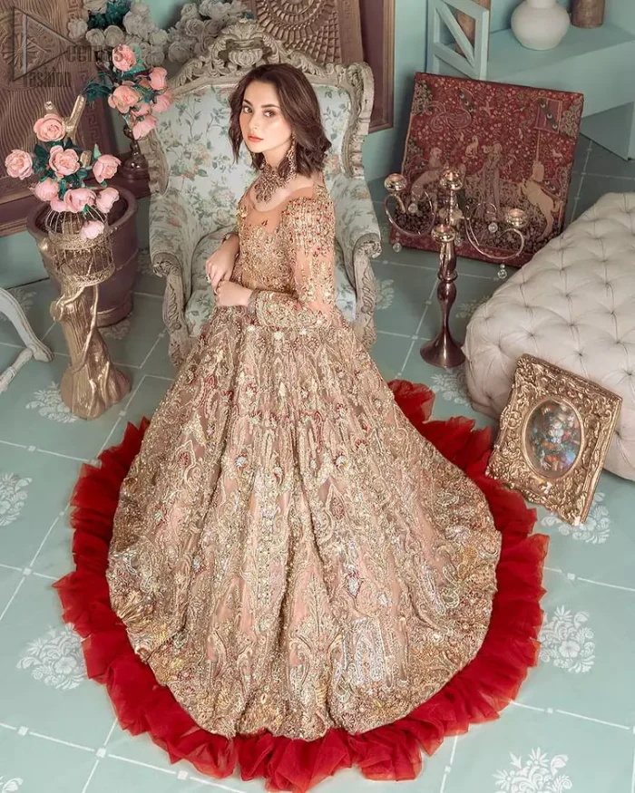 Peach Ruffled Maxi – Back Train Style Dupatta. Peach Blossoming Floral like Maxi with a frilled red border and Organza fabric is a delight to watch worn by the Bride on her Engagement or carried on the Next Day of Reception. With round neckline shape and dense work of red, golden and peach embroidery i.e multi colour conventional tilla, dabka, and Zardozi work with sequins floral motifs and climber networks of beautiful patterns all engraved through embroidery over the whole maxi with large flare and red frilled border glorifying the stitching with complete full sleeves i.e concealed with side zip line and fully embellished body too. Finished edges make the stitching stand out the best with multicolour embroidery. Dupatta has its own grace here with this splendid outfit too in peach colour with net fabric with zardozi work and fully embellished with finished edges and large coverage area with a heavy appearance on (organza) too along with floral motifs. The down below constitution consists of peach raw silk made Churidar Pajama with finished stitching and beautiful appearance making the whole outfit a choice to wear. Hence whole work has dense stitching extra toppings including kora, dabka, stones, sequins, beads, silk threads and Swarovski crystals. Along with 100% pure highest quality imported fabric.