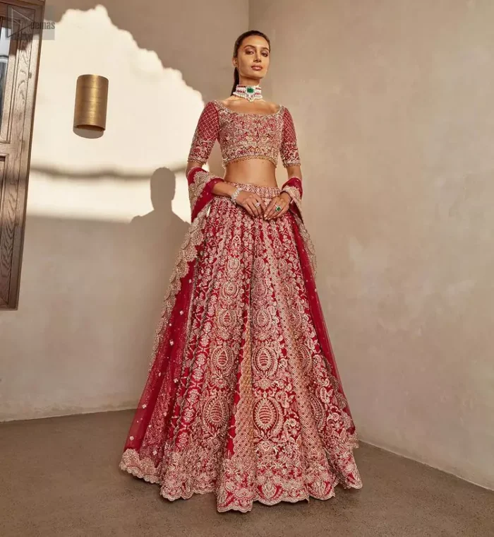It's all about looking stunning with a gorgeous Red Lehenga Blouse on your big day. Made with pure organza, this beautiful red dress is designed with trendy half sleeves, following a blouse choli styled exquisitely with a criss-cross pattern on sleeves. A boat-shaped neckline makes your beauty bones prominent while a marvellous touch of silver and golden embroidery, in addition to a few charming tassels, contributes to the magnificence of the dress. This highly appealing attire is surely going to get you a lot of praise on your Reception day.