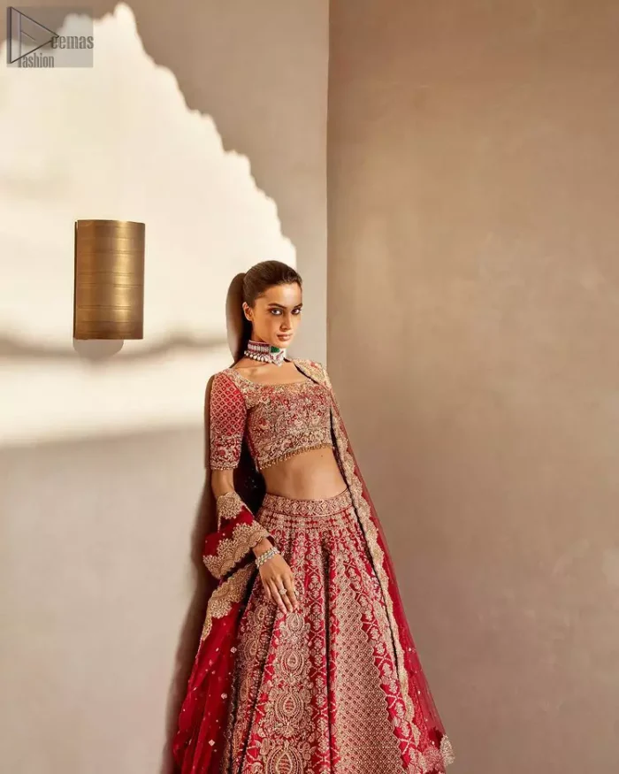 It's all about looking stunning with a gorgeous Red Lehenga Blouse on your big day. Made with pure organza, this beautiful red dress is designed with trendy half sleeves, following a blouse choli styled exquisitely with a criss-cross pattern on sleeves. A boat-shaped neckline makes your beauty bones prominent while a marvellous touch of silver and golden embroidery, in addition to a few charming tassels, contributes to the magnificence of the dress. This highly appealing attire is surely going to get you a lot of praise on your Reception day.