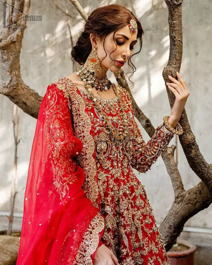 Red Bridal Peplum n Dupatta – Orange Lehenga. Red peplum with pure organza and fully engraved multi colour embroidery is such an eye-catching masterpiece that you would like to wear on your big day. Silver and golden combination of embellishment along with red pearls, Tilla Dabka, Appliques, Sequins and Zardozi work mainly gives such an eye feasting outfit to wear. The rounded, neckline and full sleeves give it a proper finishing in a beautiful attractive peplum style with Kattan Banarsi Jamawar exquisite Lehenga. With a concealed side zip closure along with floral motifs having finished edges. The Red organza dupatta has four-sided embellished borders.