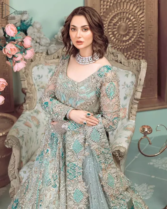This style-savvy bride totally pulled off our classic bridal wear with unmatchable grace-giving major bridal goals. Featuring beautiful handwork, this outfit has a delicate arrangement of hand-embellished floral patterns with pearls and crystals along the length. Refined craftsmanship is at its best with hand embellished zardozi work elegantly all over the outfit. Frilled on the bottom of the maxi makes the outfit look like nothing but a dream. This outfit is paired with an organza dupatta with embroidered border and raw silk churidar pajama, making it a statement piece.