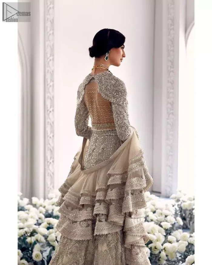 Your wedding day becomes more memorable when the guests are stunned by your majestic beauty and the perfect arrangements that are made. The Cream Lehenga Blouse is designed with such dexterity as to make you one gorgeous-looking bride on your big day. The dress code demands a full-sleeved blouse with a unique sweetheart neckline. Its exquisite fawn color is meritoriously adorned with superb silver embroidery and stylish tassels, which are indeed the most graceful works of matching embellishment. When it comes to the definition of elegance, the purest organza is specifically reserved for the creation of such marvelous attire. Followed by a beautiful dupatta and a lehenga, this charming bridal wear will make your Walima or Nikkah a heavenly day.