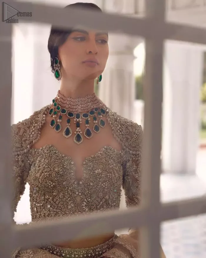 Your wedding day becomes more memorable when the guests are stunned by your majestic beauty and the perfect arrangements that are made. The Cream Lehenga Blouse is designed with such dexterity as to make you one gorgeous-looking bride on your big day. The dress code demands a full-sleeved blouse with a unique sweetheart neckline. Its exquisite fawn color is meritoriously adorned with superb silver embroidery and stylish tassels, which are indeed the most graceful works of matching embellishment. When it comes to the definition of elegance, the purest organza is specifically reserved for the creation of such marvelous attire. Followed by a beautiful dupatta and a lehenga, this charming bridal wear will make your Walima or Nikkah a heavenly day.