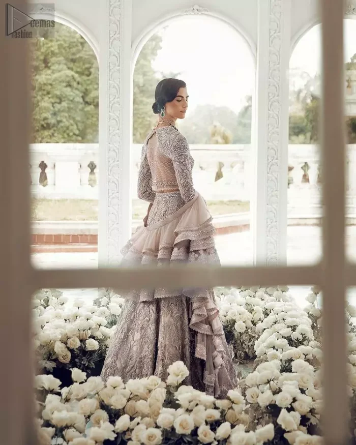 Your wedding day becomes more memorable when the guests are stunned by your majestic beauty and the perfect arrangements that are made. The Cream Lehenga Blouse is designed with such dexterity as to make you one gorgeous-looking bride on your big day. The dress code demands a full-sleeved blouse with a unique sweetheart neckline. Its exquisite fawn color is meritoriously adorned with superb silver embroidery and stylish tassels, which are indeed the most graceful works of matching embellishment. When it comes to the definition of elegance, the purest organza is specifically reserved for the creation of such marvelous attire. Followed by a beautiful dupatta and a lehenga, this charming bridal wear will make your Walima or Nikkah a heavenly day.
