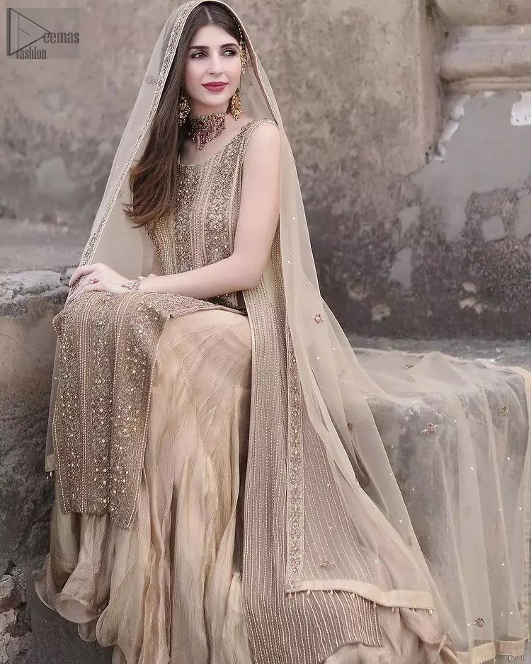 Captured in a traditional silhouette, this bridal wear stands out due to its uniqueness, the perfect fusion of modern cut and traditional embroidery. The Beige Long Shirt Sharara is beautifully decorated with heavy embroidery and adorned with kora, dabka, tilla, sequins and pearls. It comes with pure chiffon sharara, followed by organza dupatta which is sprinkled with sequins all over it. It is further furnished with a one-sided border. This marvellous attire will beautify your looks on your memorable Nikkah day.