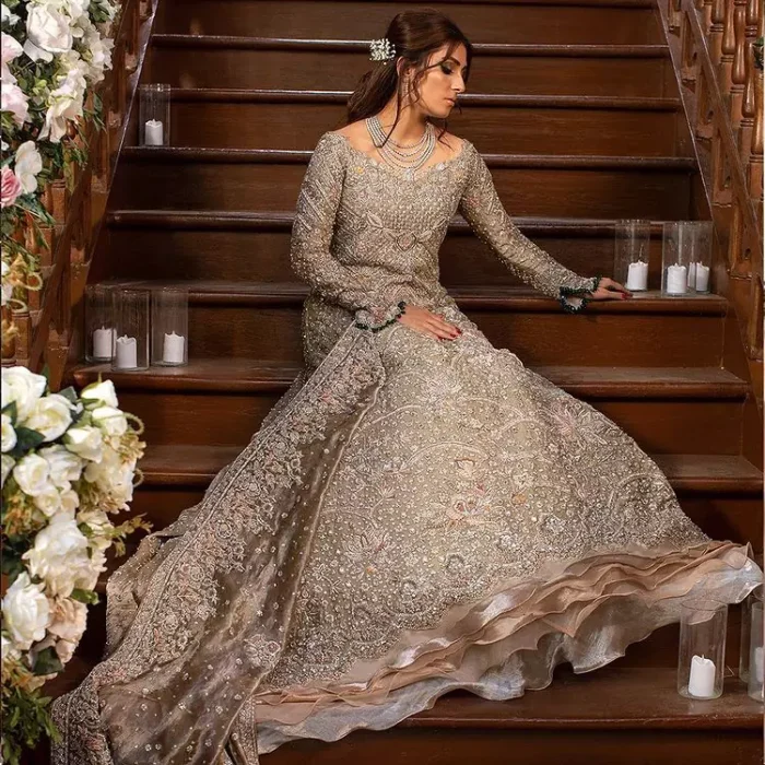 If you're seeking an imperial sensation, the Fawn Back Train Ruffled Maxi would definitely draw everyone's attention out of its soothing royal appearance. A full-sleeved maxi with a fascinating back train features a unique boat-shaped neckline to give this awesome bridal wear a western touch. To add the cherry on top, master artwork of silver embroidery is styled over its supreme matching embellishment and frilled bottom. A distinctive, yet highly gorgeous combination of a tissue maxi, a graceful silk churidar pyjama and a glamorous dupatta made out of pure organza completes this paragon of royalty. With its laudable design, this attire is surely going to make you the star of the night on your walima or nikkah day.