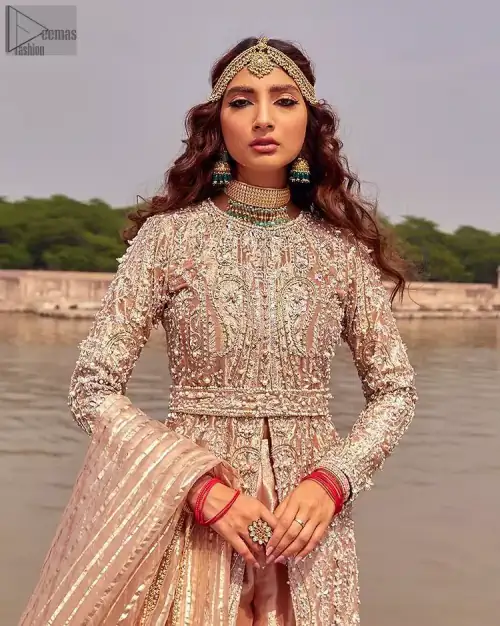 the dress with a tissue dupatta and graceful palazzo pants makes you the center of attention on your big day. Peach