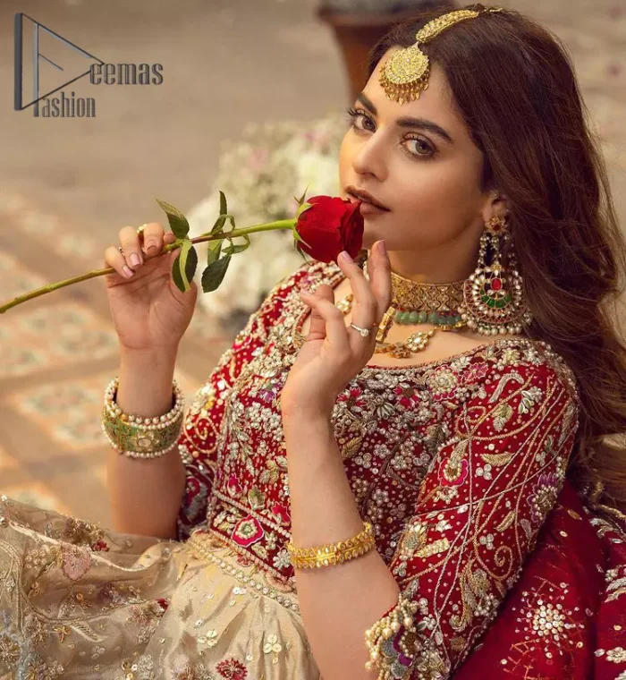 It's distinctive how the new-gen brides are welcoming red and beige shades for their bridal outfits as well. So Welcome your guest to this charming beige lehenga. The three quarter-sleeved Red Blouse  got it all for you. In addition to this, the Beige lehenga have embellished border embroidery and floral embroidery in dabka, kora work that give the stunning look. Furthermore, it is enhanced with embroidered applique bottom. The organza red dupatta that has a scalloped applique border all around the edges makes the look complete and comprehensive.