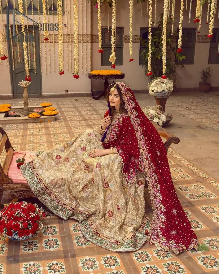 It's distinctive how the new-gen brides are welcoming red and beige shades for their bridal outfits as well. So Welcome your guest to this charming beige lehenga. The three quarter-sleeved Red Blouse  got it all for you. In addition to this, the Beige lehenga have embellished border embroidery and floral embroidery in dabka, kora work that give the stunning look. Furthermore, it is enhanced with embroidered applique bottom. The organza red dupatta that has a scalloped applique border all around the edges makes the look complete and comprehensive.