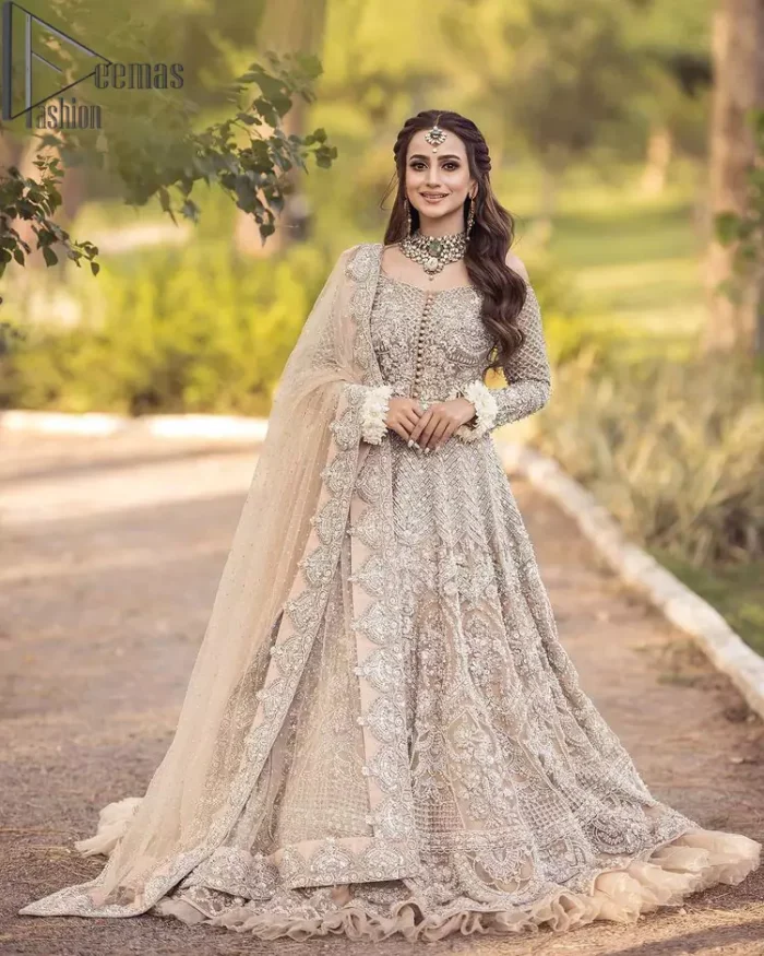 If you believed in mythical stories, shared all your secrets with glorious fairies and want to look like that mythical fairy on your reception then this Beige article is for you. This off-shoulder maxi is beautifully embellished with kora, dabka, tilla, sequins and pearls work, style up with remarkable full sleeves. Introducing this with a ruffled lehenga that looks super stunning and priceless. Followed with a net dupatta that is prominent with hand embellished borders and sequins spray all over that enhances the beauty of the outfit and give you a mythical fairy look as well.