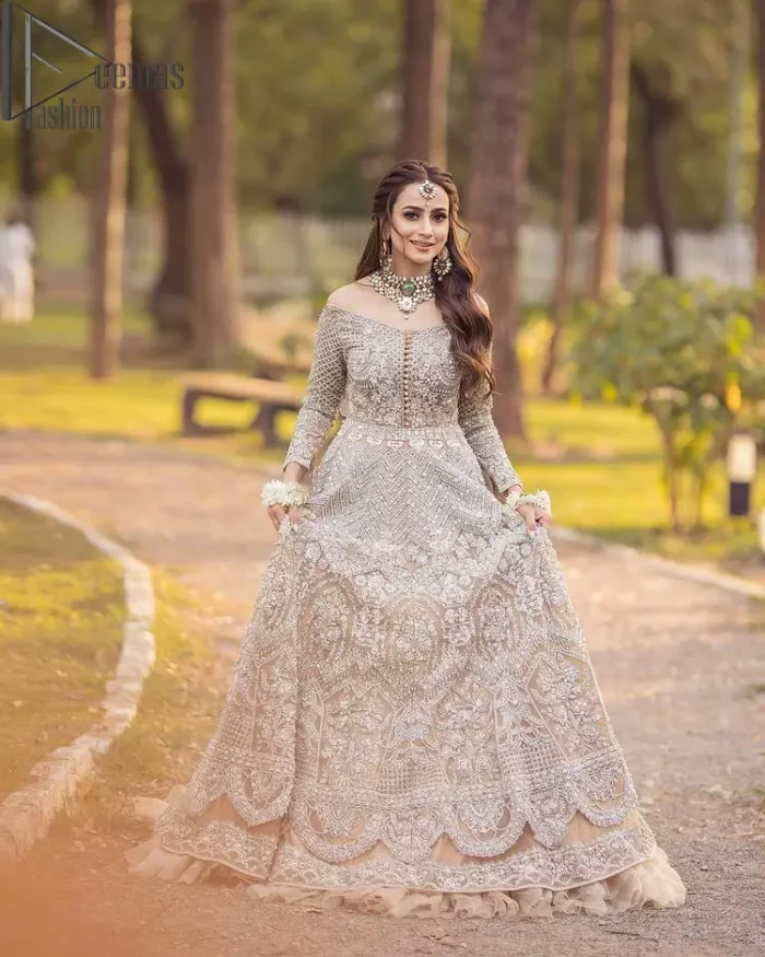 If you believed in mythical stories, shared all your secrets with glorious fairies and want to look like that mythical fairy on your reception then this Beige article is for you. This off-shoulder maxi is beautifully embellished with kora, dabka, tilla, sequins and pearls work, style up with remarkable full sleeves. Introducing this with a ruffled lehenga that looks super stunning and priceless. Followed with a net dupatta that is prominent with hand embellished borders and sequins spray all over that enhances the beauty of the outfit and give you a mythical fairy look as well.