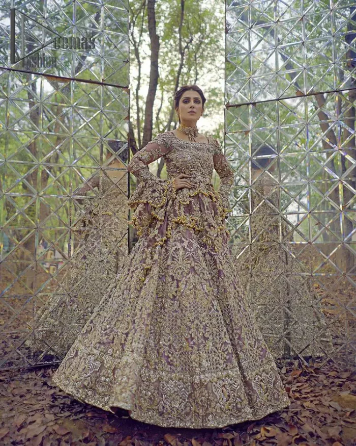 Celebrating the joy of togetherness with the light purple outfit. Grace is symbolized when it gets paired up with a light purple dupatta having a golden border and applique finishing all around the edges. The frilled sleeves of this peplum look stunning with its sweetheart neckline.  The bottom of the peplum is emphasized with an elegant arrangement of floral bunches and layer patterns. Accompanied by a matching lehenga decorated with golden zardozi work so that bride looks super-duper gorgeous on her walima day.