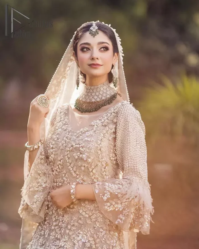 Nothing shines out more than a bride in her most natural state. For the Love of Ivory, this outfit was originally made in the shade of ivory to match the modern look in reception. This full sleeves ivory maxi is just decorated with 3D handsome flowers, style up with pearls embroidery and boat shape illusion neckline. Furthermore, the back train of this maxi gives you a super dazzling look on your reception day. Pair it up with the same colour dupatta made with pure net and embellished with a four-sided border to glamourous and enhance the combination.
