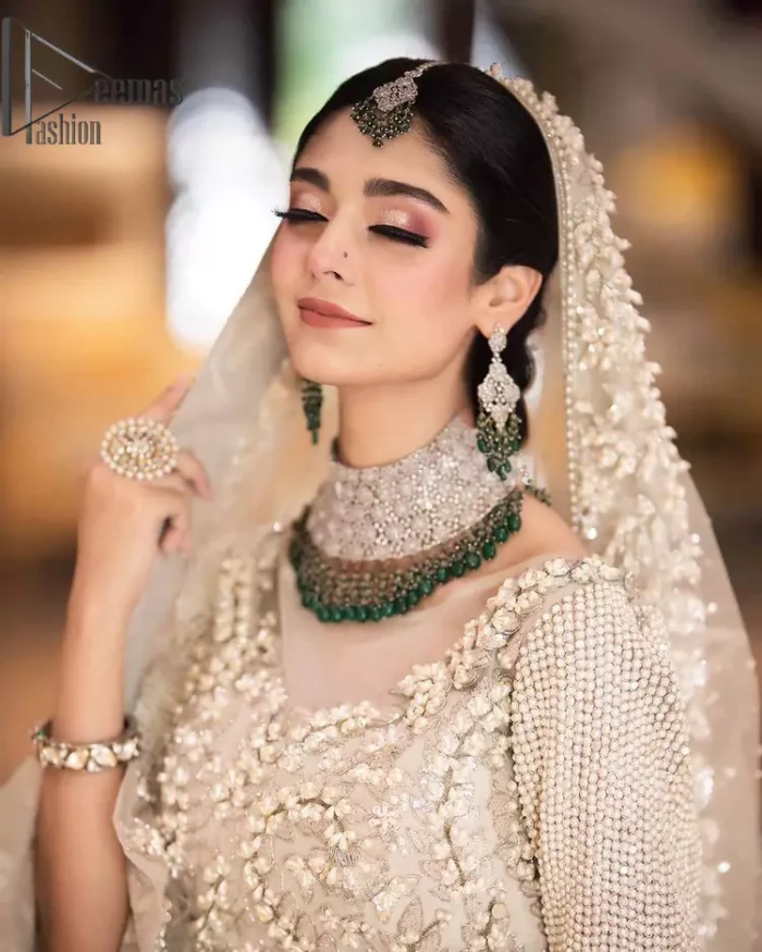 Nothing shines out more than a bride in her most natural state. For the Love of Ivory, this outfit was originally made in the shade of ivory to match the modern look in reception. This full sleeves ivory maxi is just decorated with 3D handsome flowers, style up with pearls embroidery and boat shape illusion neckline. Furthermore, the back train of this maxi gives you a super dazzling look on your reception day. Pair it up with the same colour dupatta made with pure net and embellished with a four-sided border to glamourous and enhance the combination.