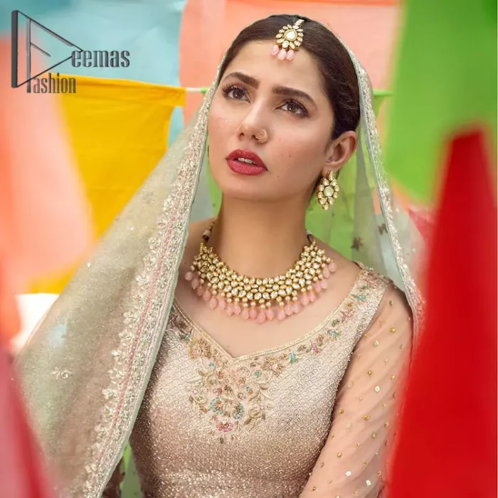 Talking about traditional, Deemas Fashion introduces the Aqua Lehenga and pink blouse which is an outstanding upgrade to bridal wear. This stunning full-sleeved attire presents an enchanting sweetheart neckline, embellished with the finest work of light golden embroidery, and adorned with pearls. This bridal wear has its own admiring look that comes with a tissue dupatta with embellished border. The Aqua colour of Lehenga gives so soothing look to the whole outfit. Furthermore, the lehenga is delicately adorned with golden kora, dabka, tilla, sequins and pearls embroidery. The border of the lehenga is also ornamented with embellished applique which gives the perfect ending to this outfit.