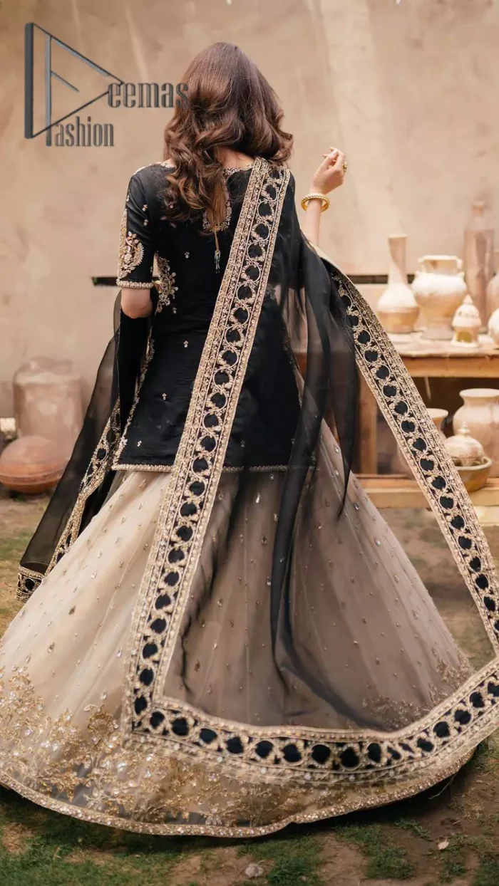 Do you want to feel like a superstar? So this stunning article is designed only for you. Just wear our black half sleeve short shirt embellished with kora, dabka and crystal work and fulfil your dream to feel like a superstar. Furthermore, It also comprises the beautiful, embellished border on the Daman. It is coordinated with a black net dupatta that is finished with geometric patterns on all four sides and comes with an Ivory can-can lehenga. The border of the lehenga is embellished with zardozi work giving a super aesthetic look to this artistic article.