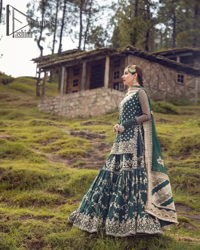 The eccentric Bottle Green outfit sings a melody just for you! The ghrara in bottle green is enriched with golden embroidery to create a modern vibe. This surprising full-sleeved shirt presents an outstanding sweetheart neckline, embellished with the finest work of golden and silver embroidery, and adorned with pearls while the details make it perfectly festive. Style it up with an organza dupatta which is sprinkled with sequins all over and four sides Kiran to give it a dreamy legal and royal look.