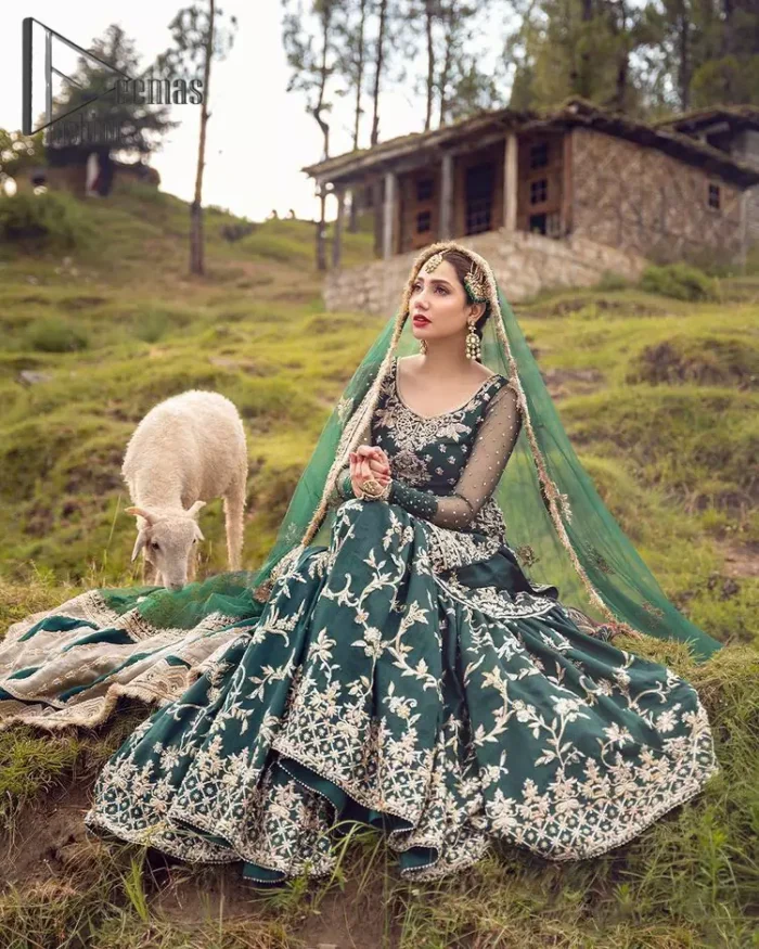 The eccentric Bottle Green outfit sings a melody just for you! The ghrara in bottle green is enriched with golden embroidery to create a modern vibe. This surprising full-sleeved shirt presents an outstanding sweetheart neckline, embellished with the finest work of golden and silver embroidery, and adorned with pearls while the details make it perfectly festive. Style it up with an organza dupatta which is sprinkled with sequins all over and four sides Kiran to give it a dreamy legal and royal look.