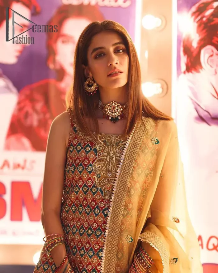 This dress is perfect for mehndi. This mehndi and mayun dress is beautifully sculptured with geometric patterns having floral motifs in it. The neckline and hemline are adorned with golden kora, dabka, tilla and sequins. It comes with golden banarsi sharara ornamented with zardozi work on borders. It comprises with organza dupatta scattered with tiny motifs and sequins spray all over the ground. 