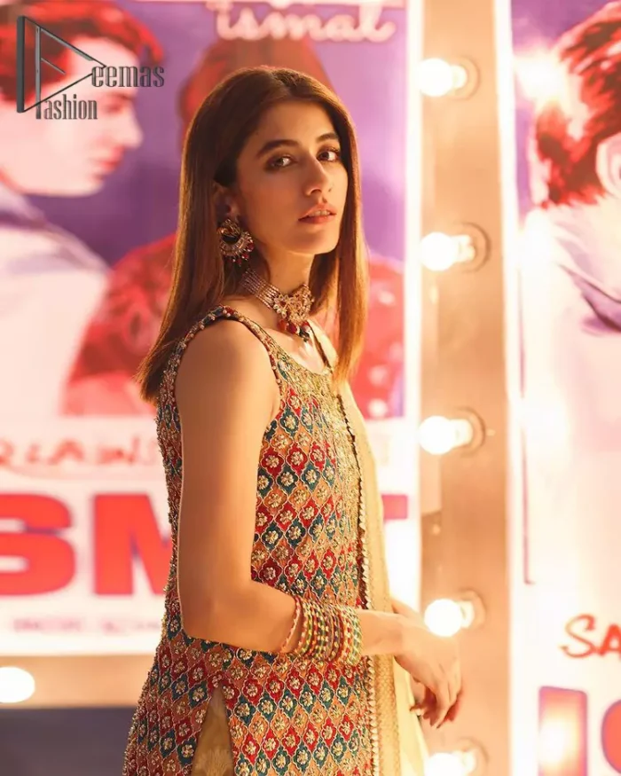 This dress is perfect for mehndi. This mehndi and mayun dress is beautifully sculptured with geometric patterns having floral motifs in it. The neckline and hemline are adorned with golden kora, dabka, tilla and sequins. It comes with golden banarsi sharara ornamented with zardozi work on borders. It comprises with organza dupatta scattered with tiny motifs and sequins spray all over the ground. 