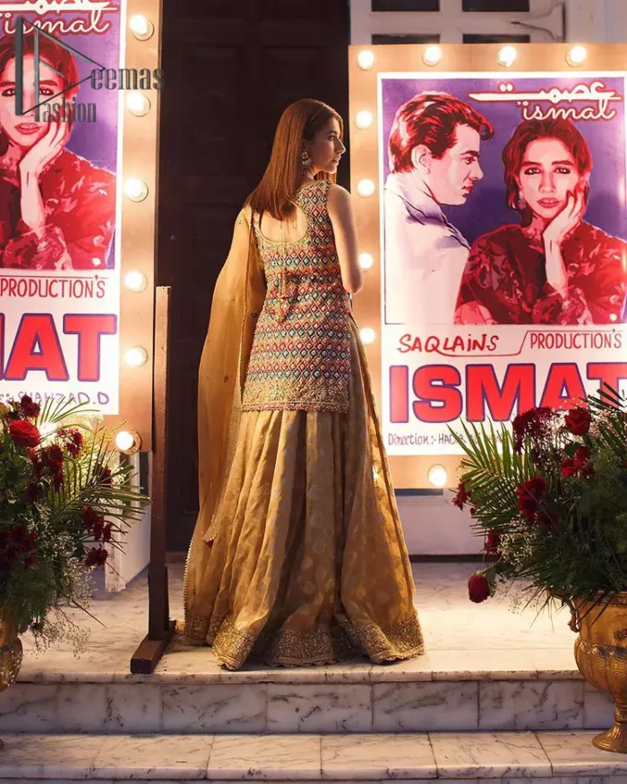 This dress is perfect for mehndi. This mehndi and mayun dress is beautifully sculptured with geometric patterns having floral motifs in it. The neckline and hemline are adorned with golden kora, dabka, tilla and sequins. It comes with golden banarsi sharara ornamented with zardozi work on borders. It comprises with organza dupatta scattered with tiny motifs and sequins spray all over the ground. 