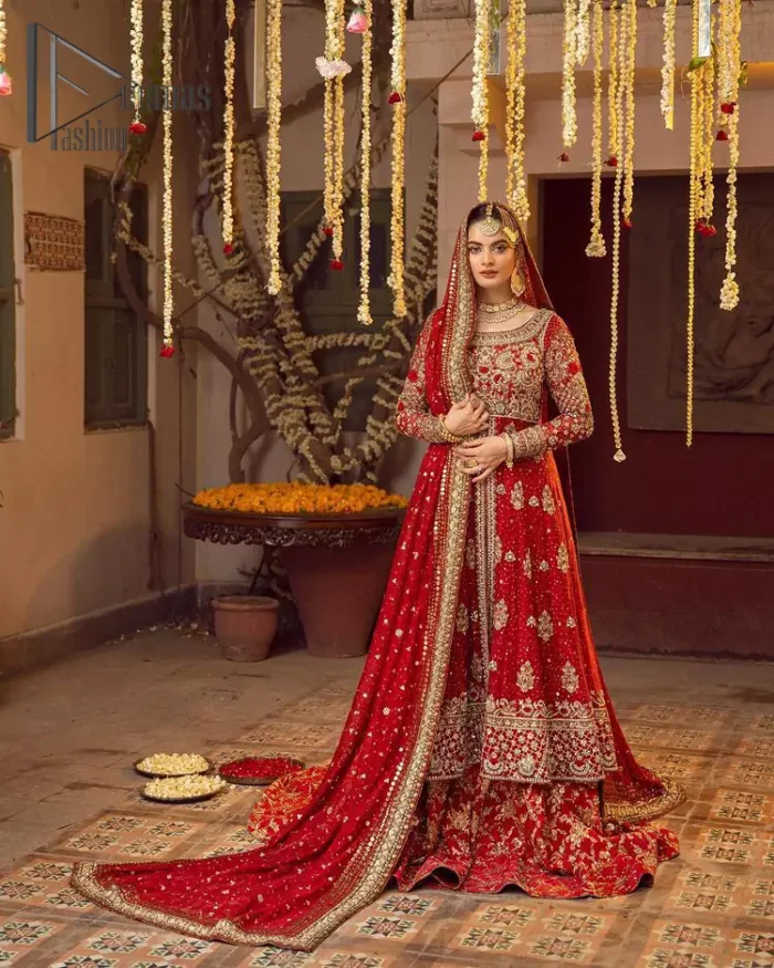Some pieces are specifically hand-crafted to speak to your heart just like this red front open Pishwas. The pishwas with a boat-shaped neckline is adorned in luxuriously zardozi work with fabulous sparkle. The rest of the dress is beautifully crafted with floral motifs, sequins spray, and embroidered lines along the length. Set it up with a red  back train lehenga emphasized with kora, dabka, tilla and sequins work. Complete the look with an artfully coordinated dupatta having embellished sequins all over and scattered tiny floral motifs.