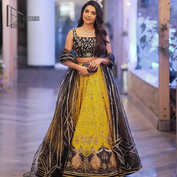 You smelled like sunshine and daisies when this pure magic wrapped around as our embroidery is luxurious. Yellow and black is the super trend of mehndi occasions. This eye-catching sleeveless black blouse having boat shape neckline looks priceless in silver and golden embroidery. In addition to this, yellow lehenga embellished with kora, dabka and sequins work and beautifully designed borders with zardozi, applique and Kiran shows the feeling of mehndi bride. Pair it up with a black dupatta that you would definitely want to wear for your next event.