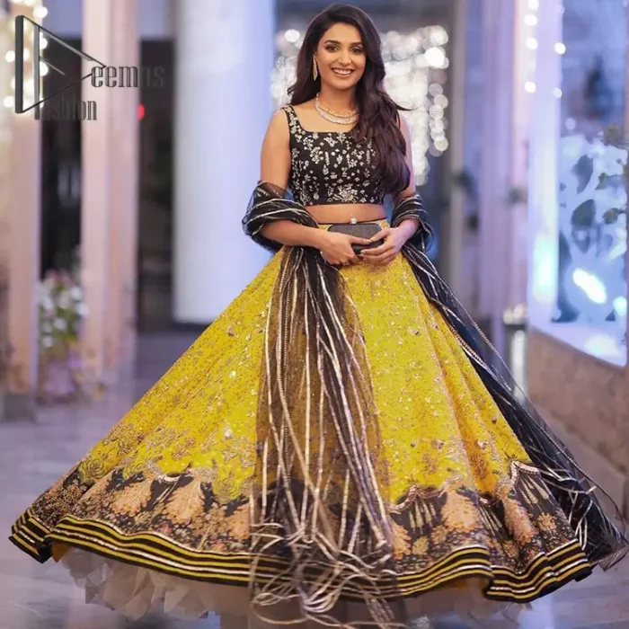You smelled like sunshine and daisies when this pure magic wrapped around as our embroidery is luxurious. Yellow and black is the super trend of mehndi occasions. This eye-catching sleeveless black blouse having boat shape neckline looks priceless in silver and golden embroidery. In addition to this, yellow lehenga embellished with kora, dabka and sequins work and beautifully designed borders with zardozi, applique and Kiran shows the feeling of mehndi bride. Pair it up with a black dupatta that you would definitely want to wear for your next event.
