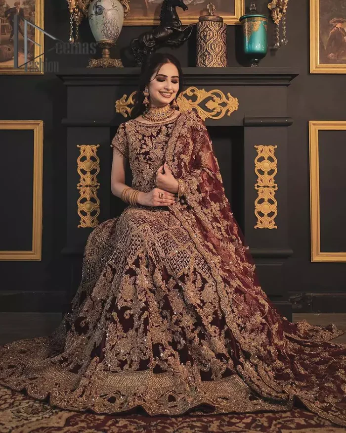 With the right outfit, every bride can rule the world! As nothing makes a bride more beautiful than the trust of her outfit. Introducing maroon half sleeves blouse that is fully embellished with tilla, kora and dabka work. In addition to this, the boat shape neckline of this blouse that is made with pure velvet gives you a dreamy look. It is synchronized with a velvet lehenga that is adorned with priceless heavy embroidery. Finish this look with an organza dupatta, embellished with embroidered scalloped borders to give you a relaxing and soothing look on your reception.