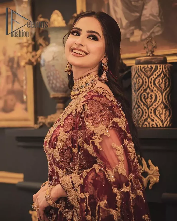 With the right outfit, every bride can rule the world! As nothing makes a bride more beautiful than the trust of her outfit. Introducing maroon half sleeves blouse that is fully embellished with tilla, kora and dabka work. In addition to this, the boat shape neckline of this blouse that is made with pure velvet gives you a dreamy look. It is synchronized with a velvet lehenga that is adorned with priceless heavy embroidery. Finish this look with an organza dupatta, embellished with embroidered scalloped borders to give you a relaxing and soothing look on your reception.